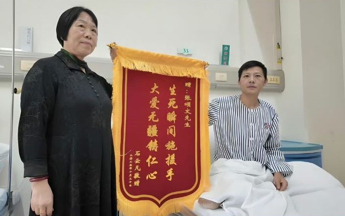 獲救的石姓男子特別製作錦旗向張頌文表達感謝,錦旗上寫著「生死瞬間施援手,大愛無疆鑄仁心」。圖/取自影片