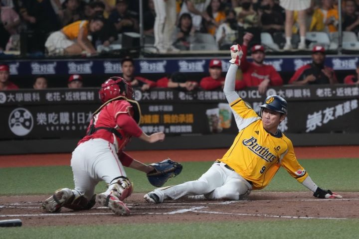 台灣大賽由味全龍隊與中信兄弟隊爭冠,21日關鍵第4戰6局下半,兄弟王威晨(右)從二壘一路奔回本壘,經重播輔助判決確認成功得分,助隊追平比數。圖/中央社