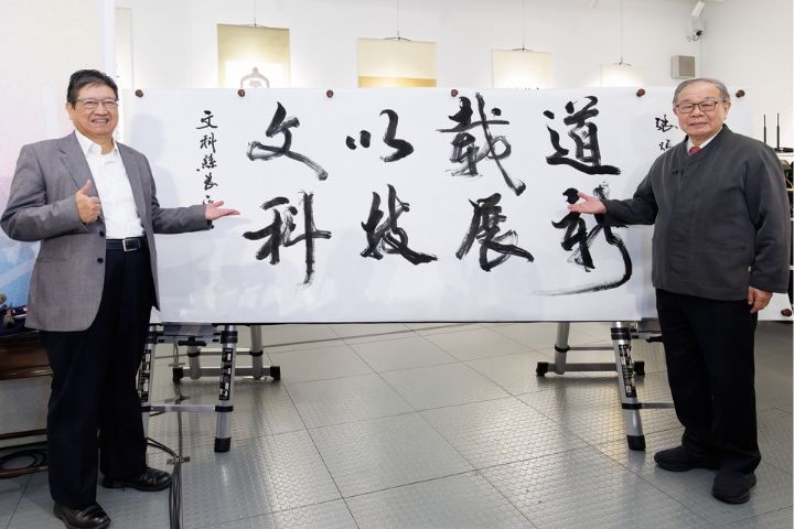 張炳煌教授現場揮毫「文以載道、科技展新」，感謝新竹縣長楊文科（左）對藝文發展的支持。圖/億光文教基金會提供