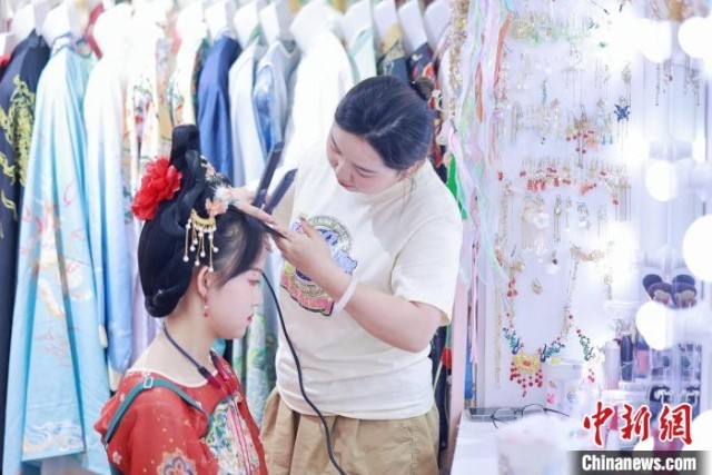 一位漢服妝造師正在給客人做造型。圖/取自中新網