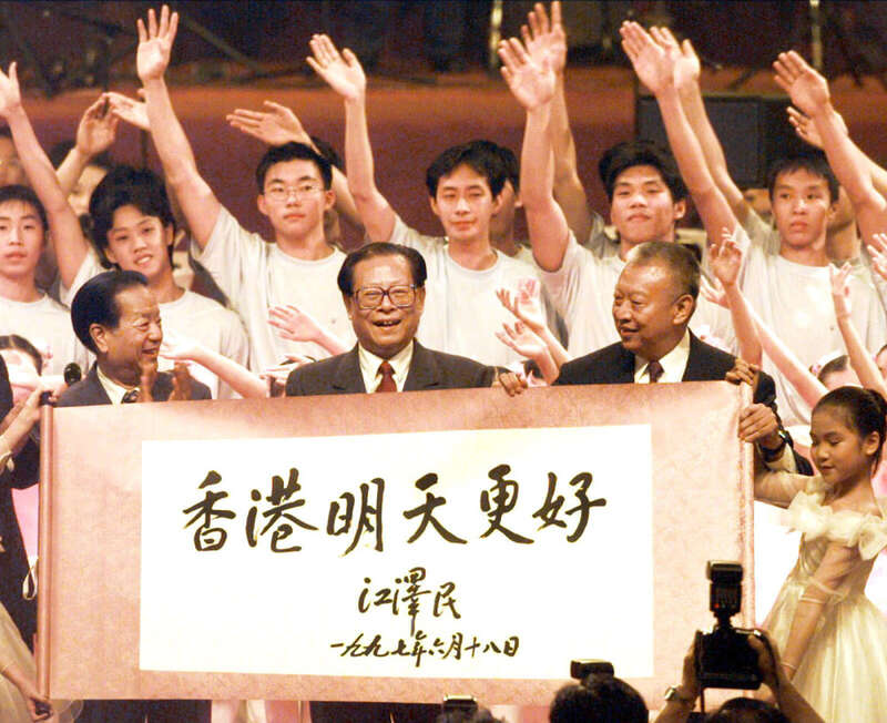 1997年香港回歸,中共總書記江澤民(中)在國務院主管港澳副總理錢其琛( 左)陪同下親赴香港與會,其右為第一任香港特首董建華。圖/取自央視