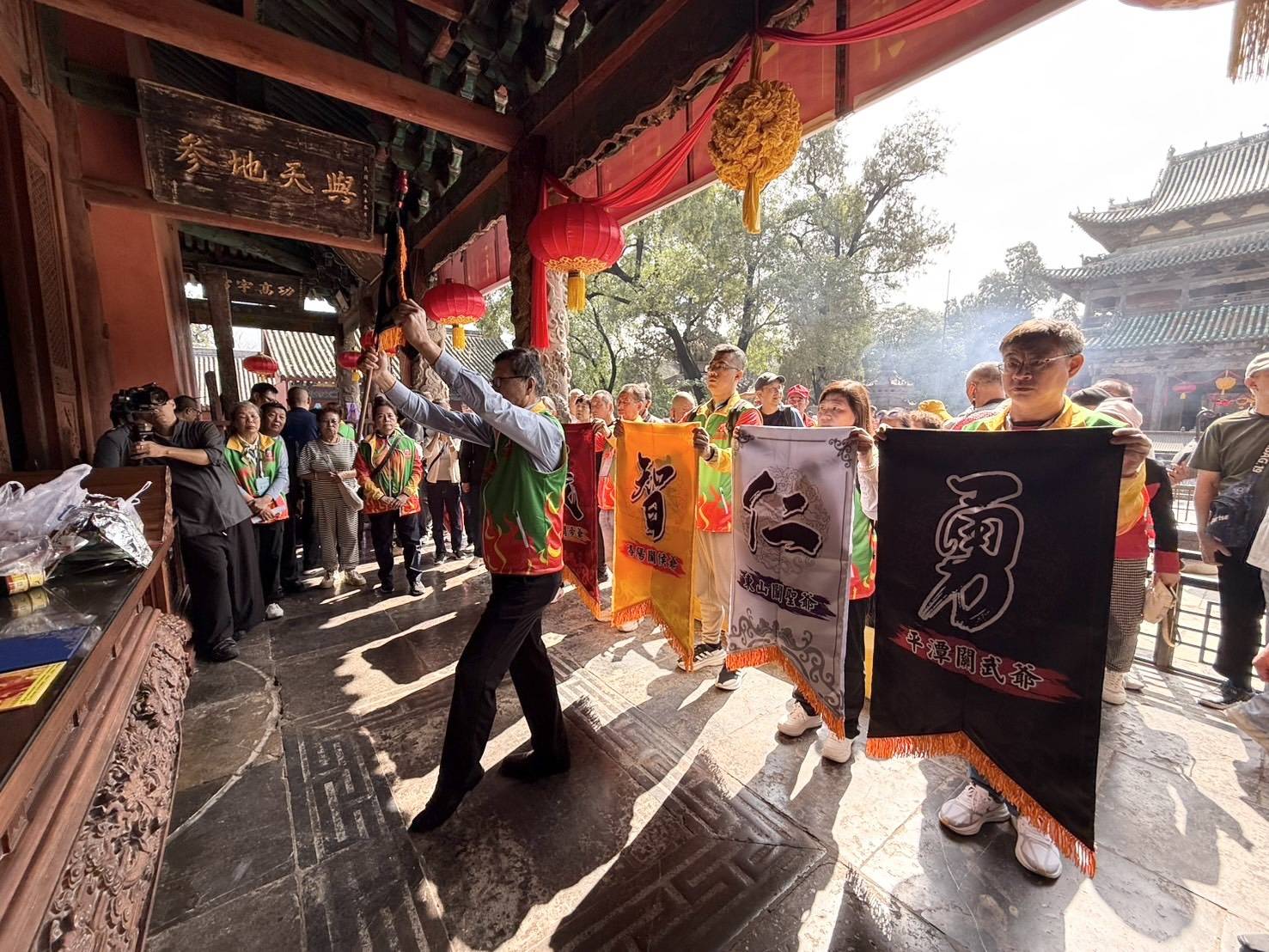 游同人理事長率團眾，致敬關公祖廟神尊前敬請正統令旗。圖/記者張蔭泉攝