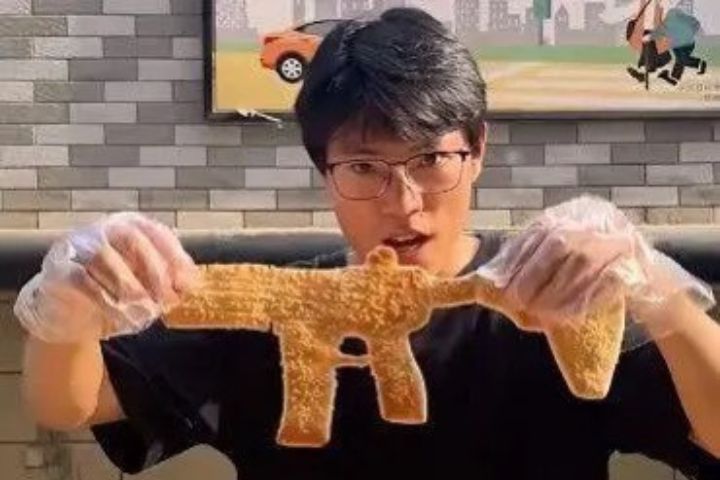 攤主小楊為滿足一位小朋友的「點單」，嘗試做出步槍造型燒餅，結果瞬間爆紅。圖/取自央視