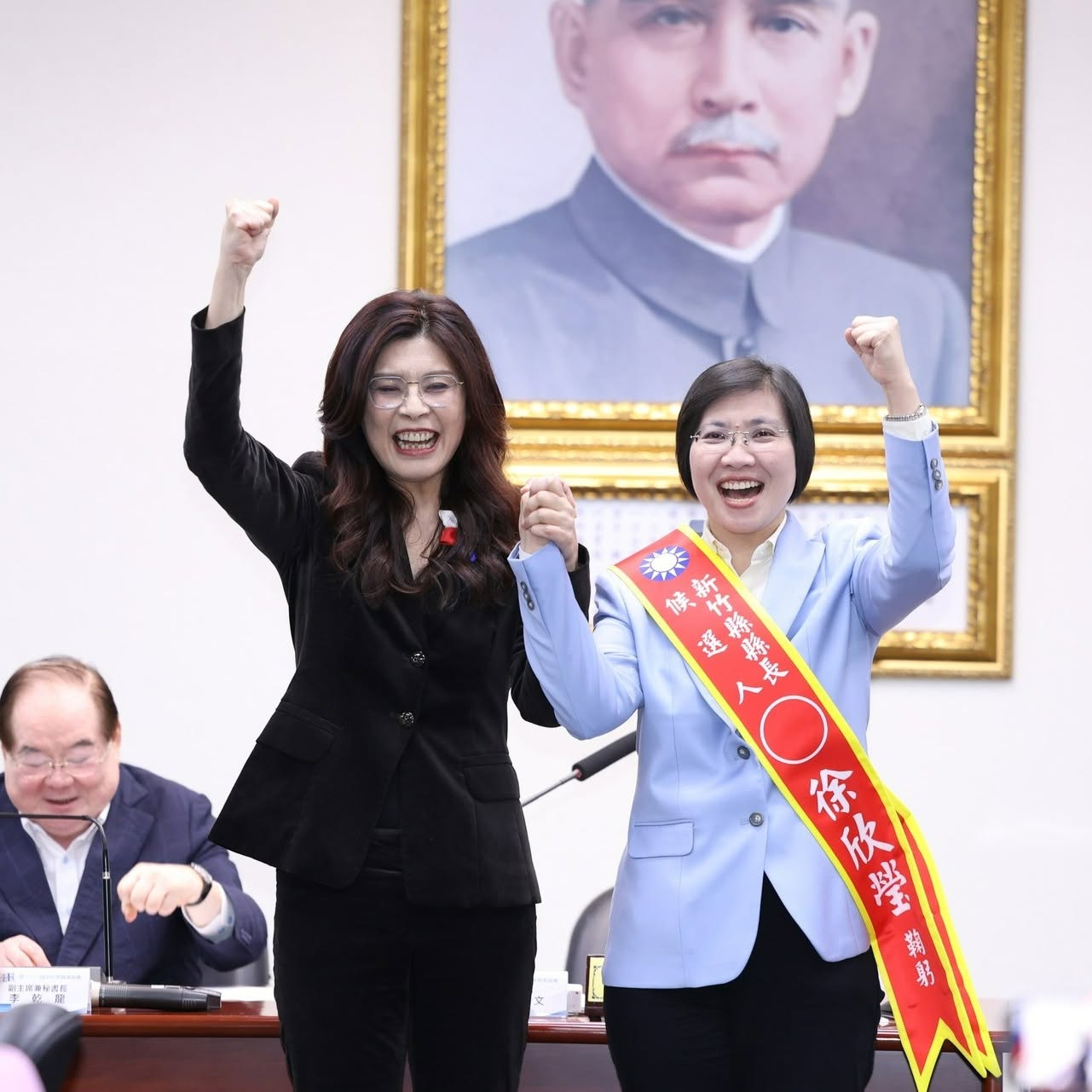 新竹縣初選徐欣勞獲勝後,國民黨主席鄭麗文在中常會為徐欣瑩右(右)披戰袍。圖/取自徐欣瑩臉書