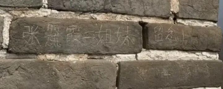  女子在長城城牆磚石刻下「張某霞二姐妹留念」字樣。圖/取自大風新聞
