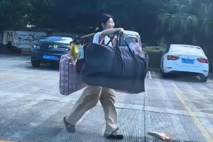 劉燕背著書包、用木扁擔挑著鋪蓋與行李獨自返家的畫面被路人拍下。圖/取自微博影片