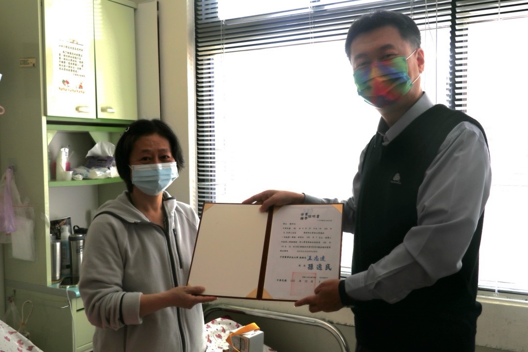 中華醫事科大教務長王志達親贈修業證書，亟盼癌末天使鄭伊均抗癌成功，回母校圓夢。圖/周大觀文教基金會提供