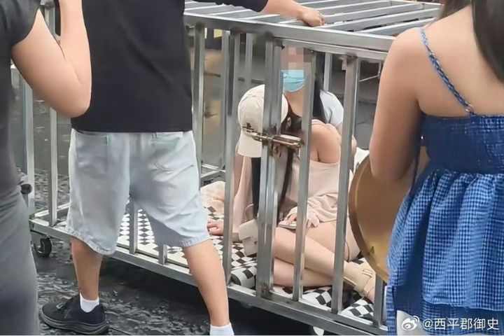 一名38歲男子為博取流量收益，策畫「鐵籠關人遊街」橋段，並找來多人分飾籠中女子、牽狗者及現場群眾。圖/取自西平郡御史微博