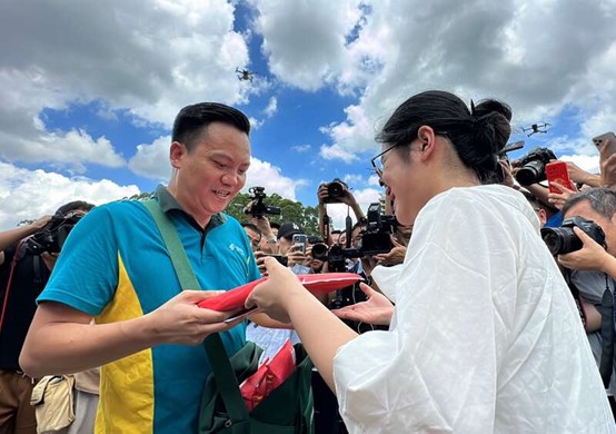 塗蘇藍從郵差手中接到錄取通知書。圖/取自中青網