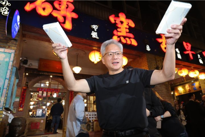 輝達執行長黃仁勳(前)31日晚間在台北宴請台灣供應鏈夥伴高層,黃仁勳在宴席中一度步出店外,親手發放餐盒給現場守候的記者。圖/中央社