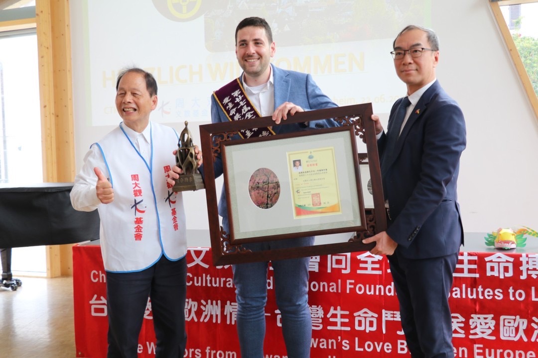 周大觀文教基金會創辦人周進華，及外交部慕尼黑辦事處處長趙彥清一起頒發2024年第27屆全球熱愛生命獎章，肯定全球第一位難民市長阿爾謝布爾（Ryyan Alshebl）。圖／周大觀基金會提供