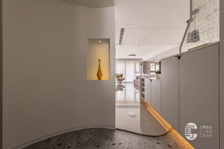 以曲面量體柔化斜切格局，巧寓舍計鋪陳藝術端景與六角磚地坪，串起流動迎賓序列。圖/歐德集團提供