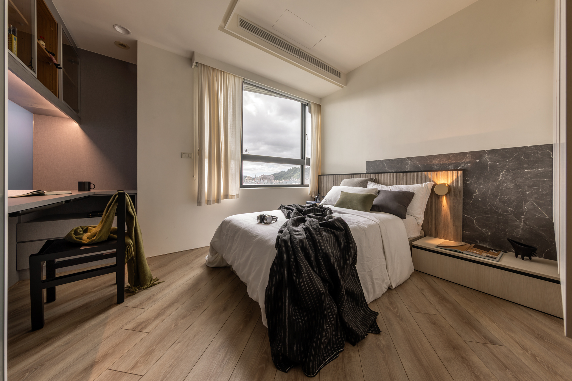 床頭牆結合層板櫃,搭配格柵與石紋,全室斜拼鋪設榮獲綠建材的Order floor超耐磨木地板,添活潑氣息。圖/歐德提供