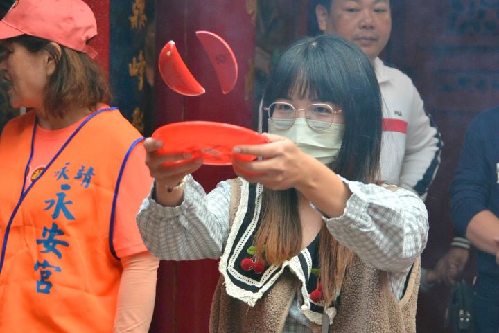 民眾於永安宮參與「擲筊挑戰賽」,親手擲筊向神明祈福,感受永靖歲末謝平安的傳統信仰儀式,現場氣氛熱絡。圖/頂新和德文教基金會提供