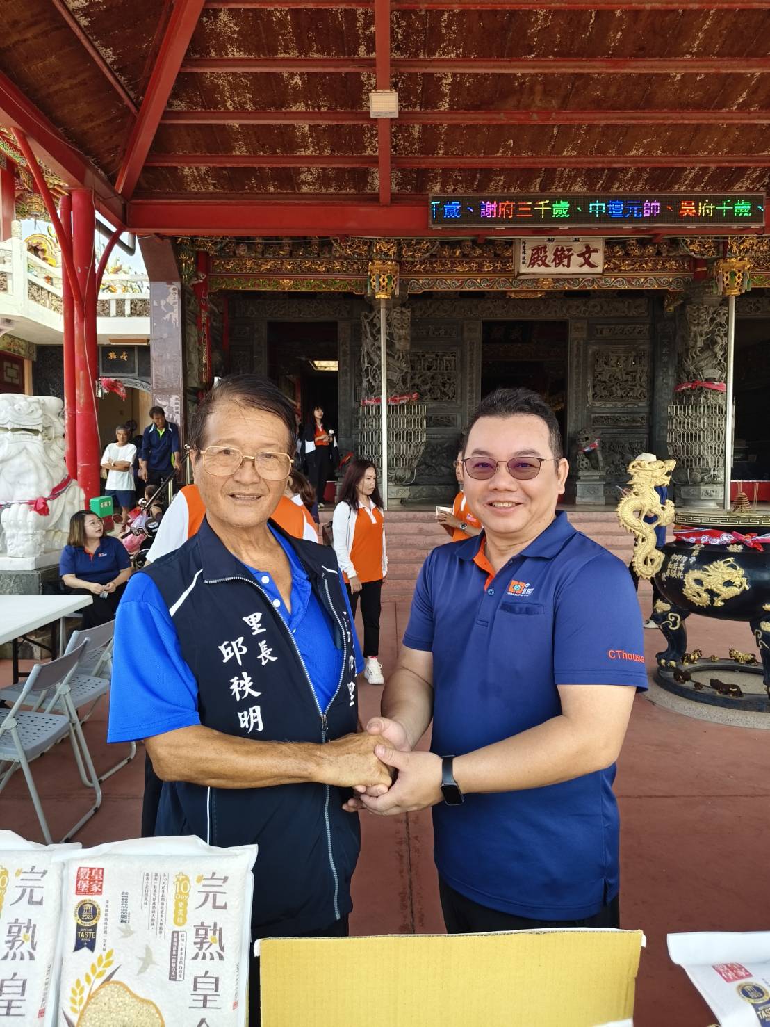 在篤加里邱秩明里長（左）的協助下，中信房屋的店東長及夥伴們齊心協力完成物資集中。圖/中信房屋提供 