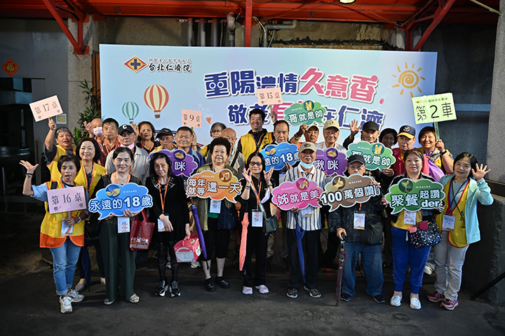 長輩們在看板前齊聚拍照，參加重陽餐會已成長輩們每年的固定樂趣。圖／台北仁濟院 提供