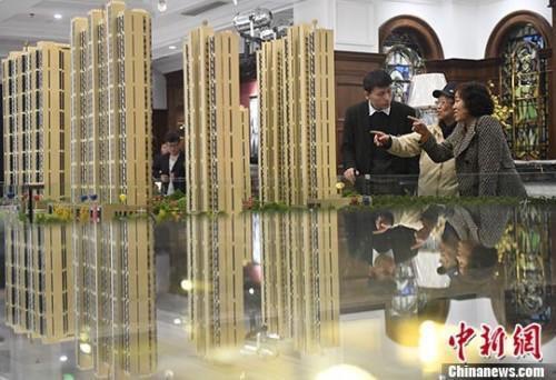 銷售人員為看房者推介新房。圖／取自中新網