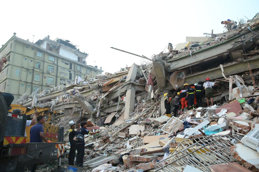 緬甸28日發生規模7.7強震，災情慘重，許多地區房屋倒塌、嚴重毀損。圖為救援人員30日在缅甸曼德勒天空别墅搜尋生還者。圖/取自新華社
