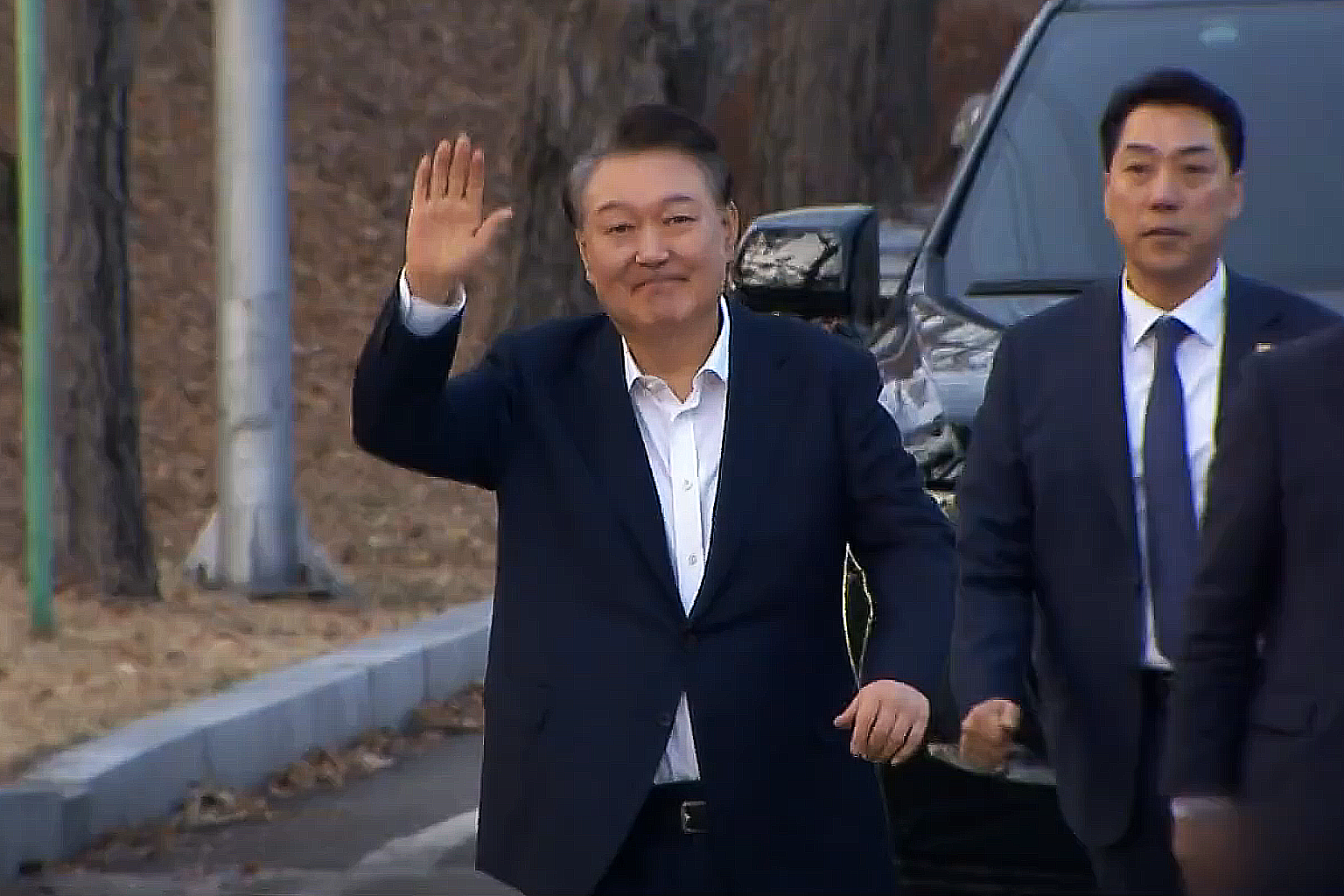 南韓總統尹錫悅未親自到場，而是在官邸透過電視直播觀看宣判結果。圖為尹錫悅8日獲釋向民眾揮手致意。圖/翻攝自KBS News YouTube頻道