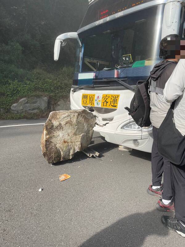 客運駕駛看見落石掉落緊急煞車，僅造成車頭輕微受損。圖/中央社