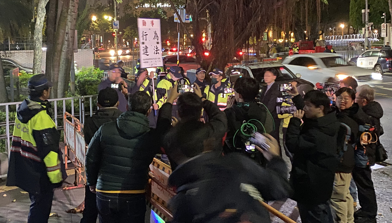 前台北市長柯文哲涉京華城等案，台北地院26日晚間召開羈押庭審理。在北檢旁聲援的「小草」們突然衝至北檢門前抗議，遭警方舉牌警告。圖/ 中央社