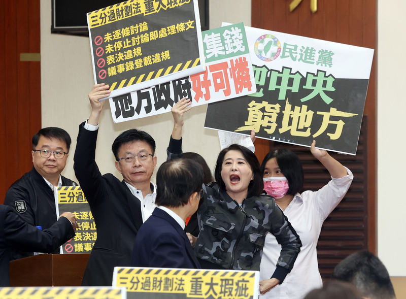 民進黨立委吳秉叡（左）11日在立法院財政委員會提案，認為不應確認《財劃法》議事紀錄；而後藍綠立委吵成一團，雙方爭執不休。圖／中央社