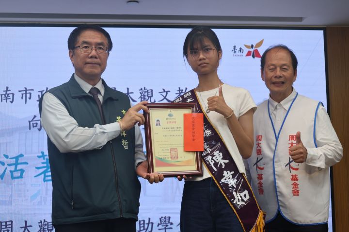 台南市長黃偉(左)哲頒獎給罕癌綠能工程師陳韋如(中)生命鬥士獎。圖/周大觀文教基金會提供