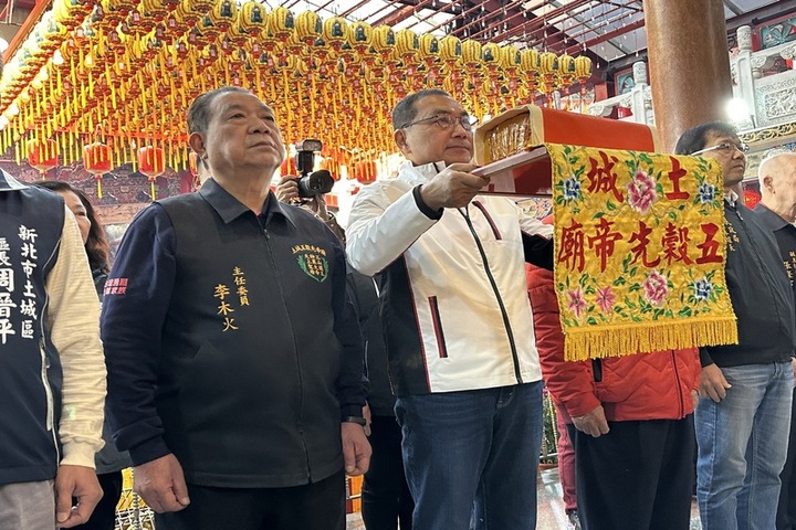 新北市長侯友宜（中）春節期間赴各地拜廟祈福並發放福袋，吸引許多民眾排隊領取。圖為侯友宜在土城五穀先帝廟參香。圖/取自中央社