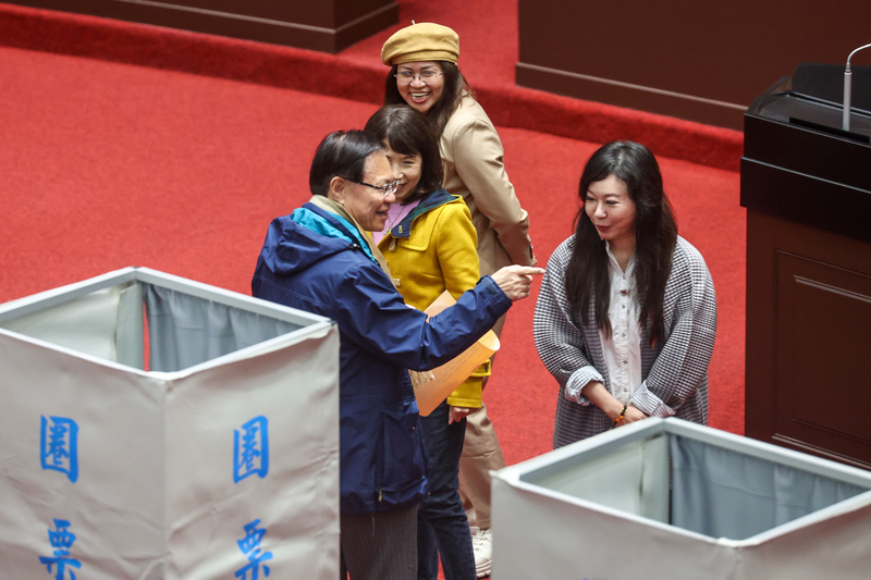 立法院會24日上午進行司法院大法官人事同意權案記名投票表決，民眾黨立委張啓楷（藍衣）圈票後與同黨立委交換意見。圖/中央社