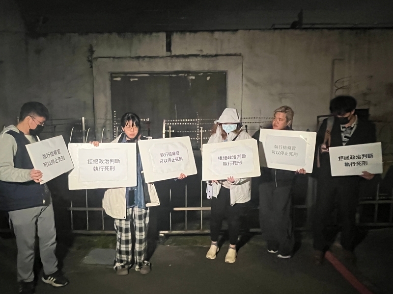 法務部16日晚槍決死囚黃麟凱，民間司法改革基金會成員（圖）在台北看守所外呼口號。圖/中央社
