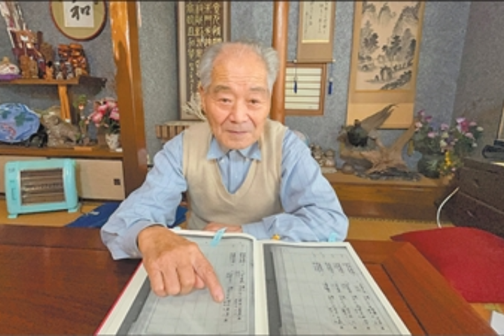 731部隊前隊員清水英男接受《人民日報》訪問時，向記者介紹寫有自己名字的「731部隊留守名簿」。圖／取自人民日報