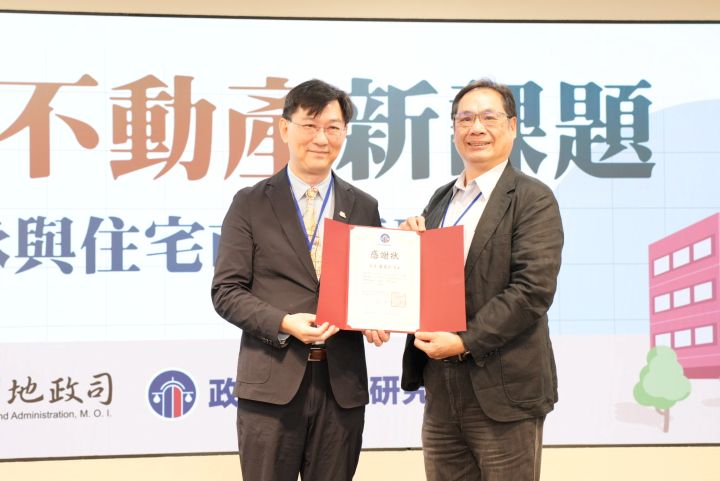 政大不動產研究中心主任楊松齡(右)致贈感謝狀給內政部政務次長董建宏,表彰政府在加速都更、危老重建政策面的努力。圖/梅花新聞網記者陳思豪攝