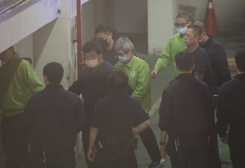 羈押中的前台北市長辦公室主任李文宗（中）戴著口罩、身穿綠色上衣者，26日被法警押往北檢。圖/中央社