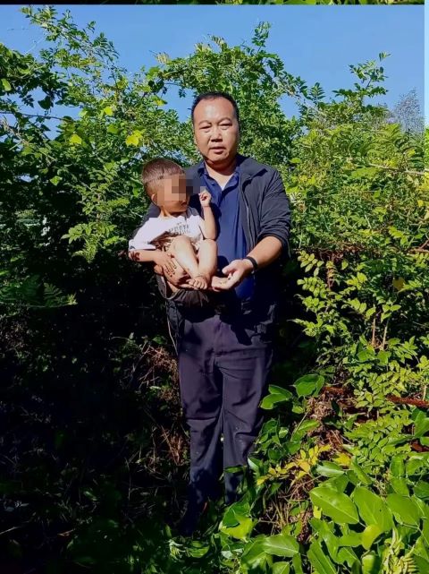 搜救隊隊長楊先生從灌木叢中抱出男童。圖/取自紅星新聞