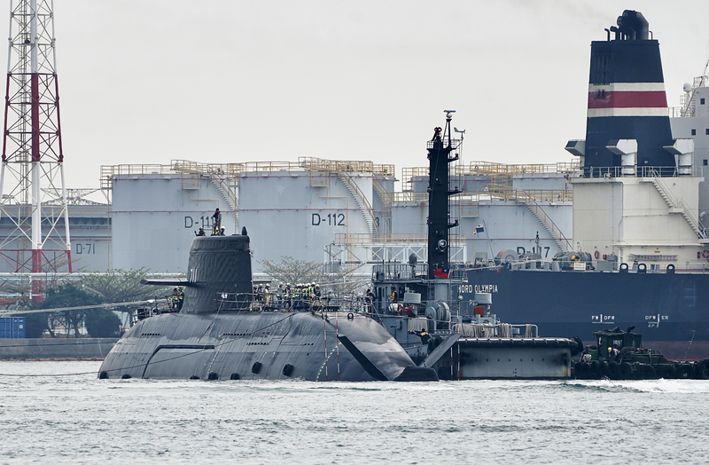國造潛艦海鯤軍艦進入泊港測試（HAT）最後階段，27日分3階段從中信8號浮塢移至台船小塢，下午進行第3階段拖帶進塢時，海鯤艦半截船身浮在水面。圖/中央社