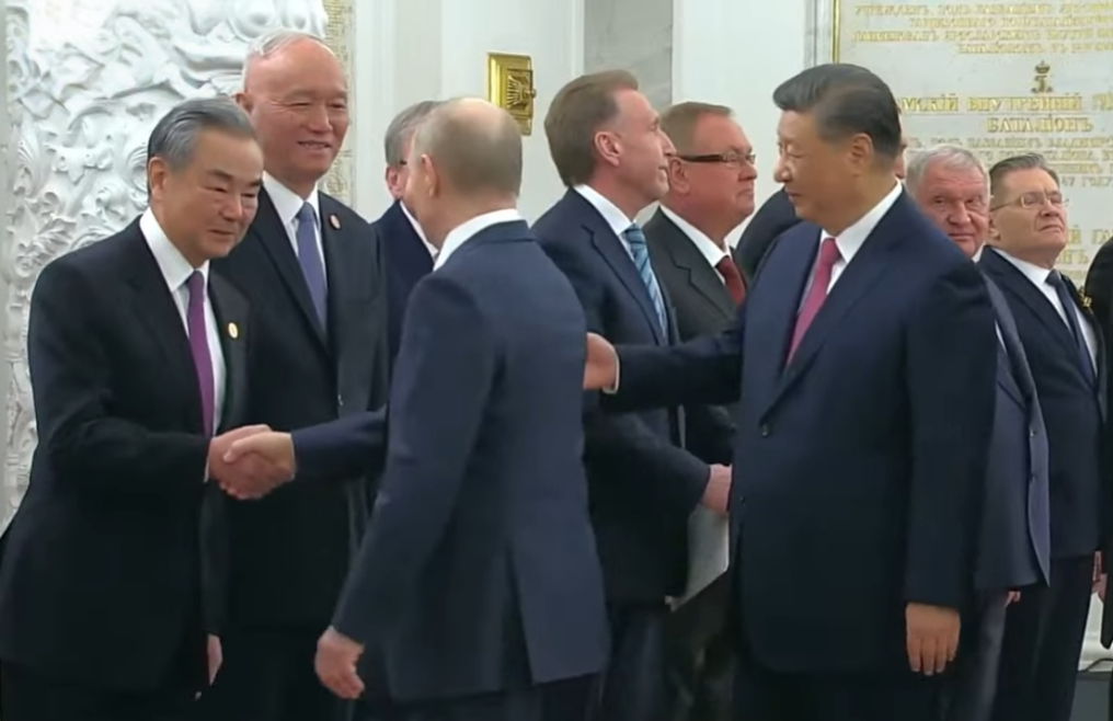 圖為中國國家主席習近平(右)在普丁(背對鏡頭)抵達後,向其介紹中國外交部長王毅(左)等人。圖/翻攝自CNBC-TV18 YT頻道