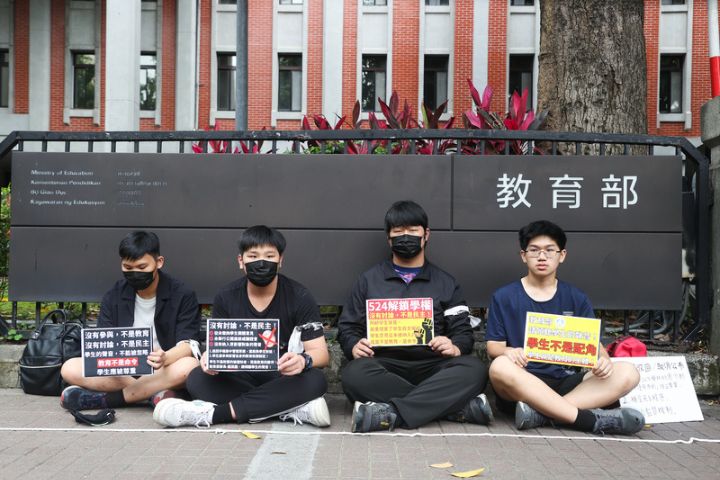 教育部日前公布「高級中等以下學校學生攜帶行動載具到校管理原則」草案，學生團體不滿決策倉促、邊緣化學生意見，24日在教育部前發起靜坐。圖/ 中央社