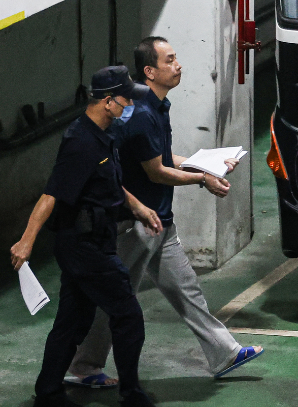 圖為國民黨北市黨部書記長初文卿步上囚車的畫面。圖/中央社