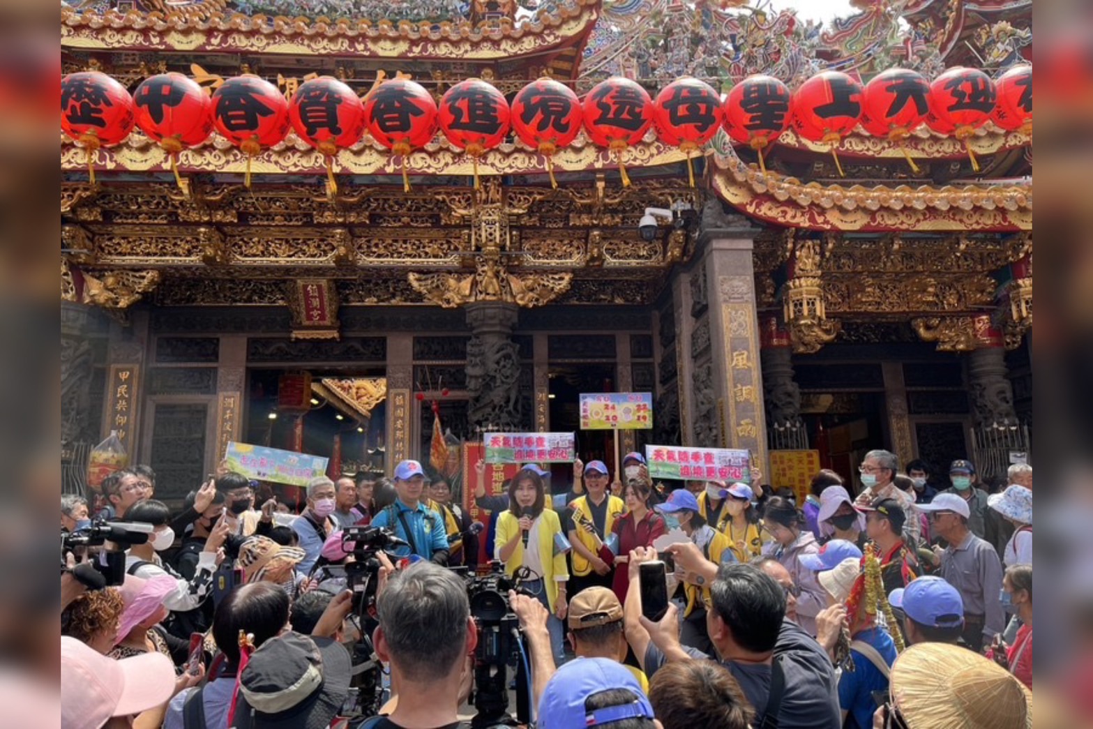 資深預報員伍婉華（黃衣）在現場秀台語表示，希望大雨不要落在遶境途中。圖／中央社