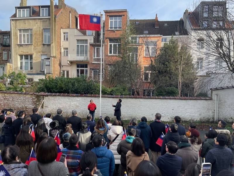 海外國人都很珍視每個中華民國國旗升起的機會，圖為今年元旦國旗在比利時僑校升起。但廖偉翔揭露，外交部駐外單位竟讓國人自己去買。圖／取自中華民國僑務委員會