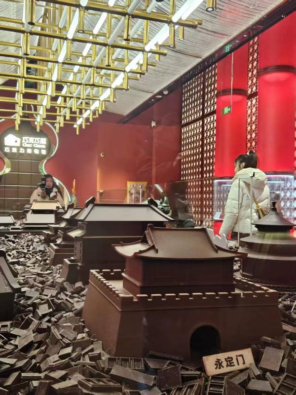 長近8公尺的北京中軸線巧克力工藝品,按真實比例複刻永定門、正陽門、天安門、故宮、景山、鐘鼓樓等中軸線上的標誌性建築物。圖/中新社記者 張小靜攝