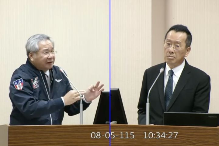 民眾黨立委許忠信（左）於立院外交國防委員會大秀空軍夾克，國防部長顧立雄（右）列席備詢，神情疑惑。圖/取自國會頻道直播