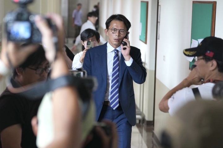 立法院27日下午進行黨團協商，民眾黨立委黃國昌（中）邊講電話邊走進會議室。圖/中央社