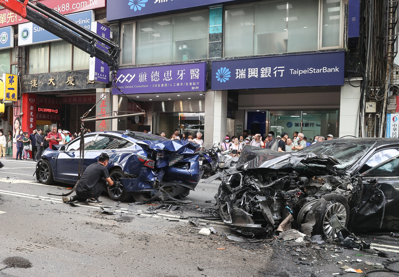 台北市重慶南路一段今日下午發生車禍事故，現場黑色自小客車頭與藍色自小客車尾嚴重毀損。圖/中央社