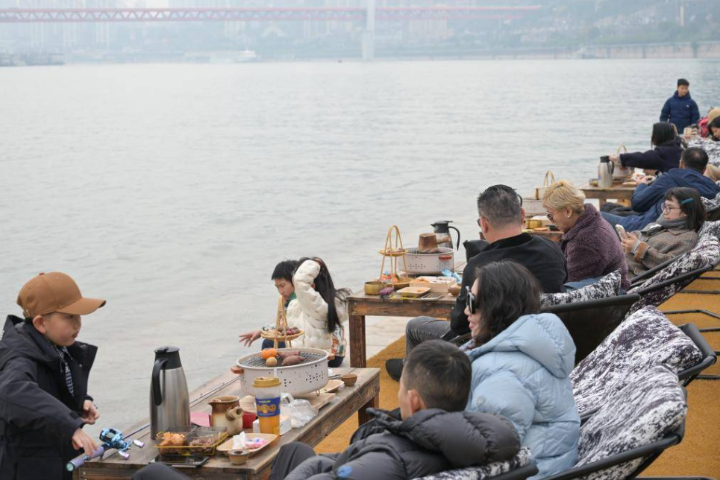 2025年12月，重慶市民、遊客在長江畔圍爐煮茶，體驗冬日休閒新場景。圖/ 中新社記者何蓬磊攝