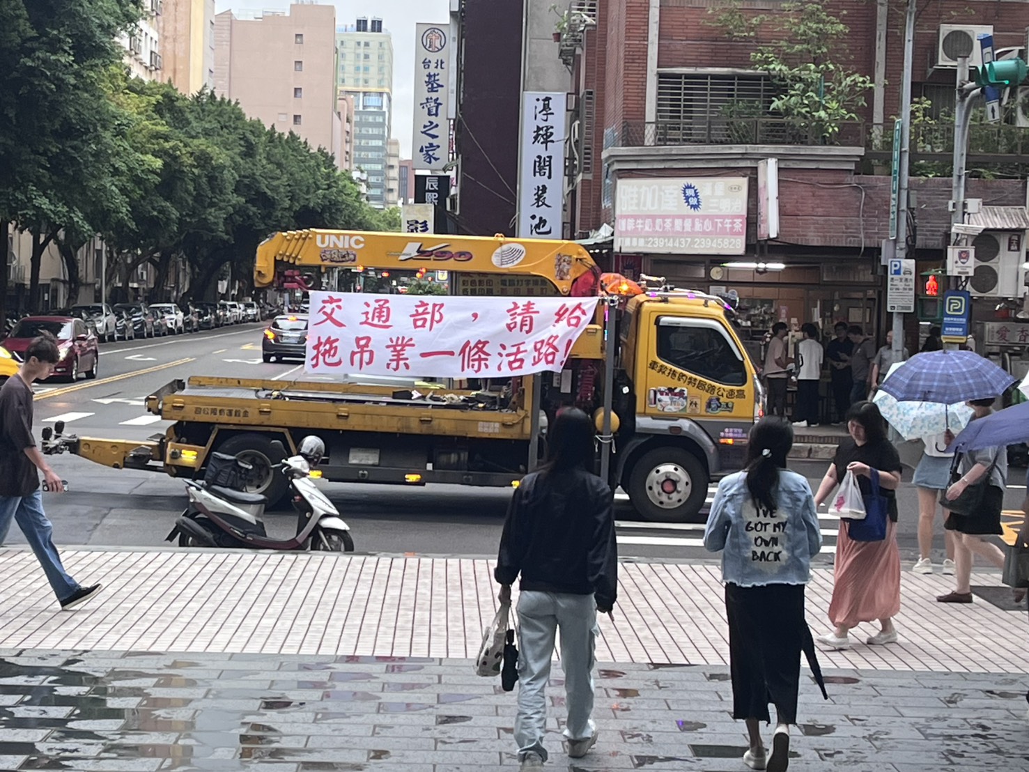 中華民國柴油車運輸總會指控交通部長期漠視拖吊業者權益，3日號召業者前往交通部外集結抗議，多輛大型拖吊車高掛布條爭取權益。圖/記者黃楚甯攝