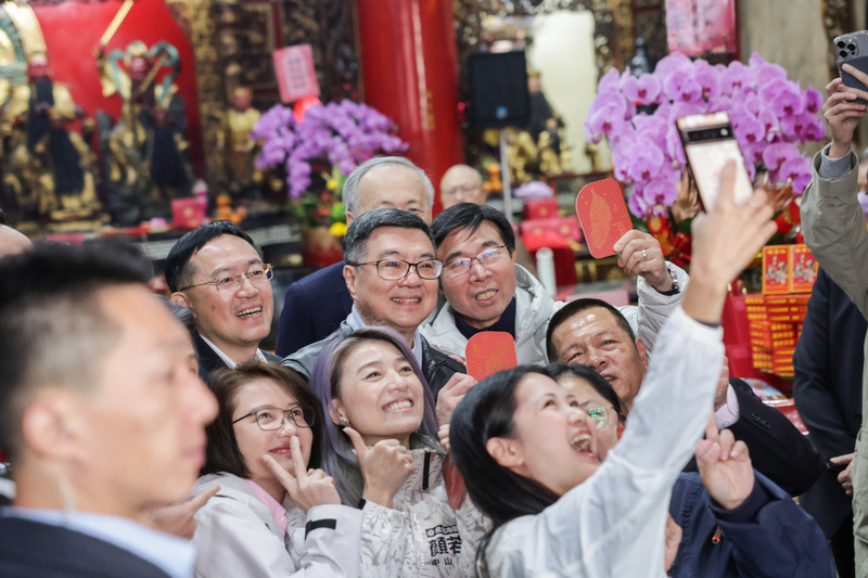 行政院長卓榮泰（後排左2）大年初一到台北覺修宮參拜祈福，與在場人士自拍合影。圖/中央社