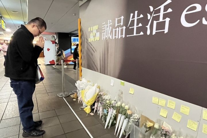 22日是張文隨機攻擊案後的第一個上班日,北捷統計乘車數未減,有民眾在擺滿花束事發現場悼念見義勇為犧牲的余家昶。圖/中央社