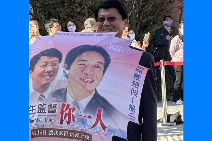 謝龍介帶著印有自己與爛清德頭像的大傘到立院報到。圖/讀者提供