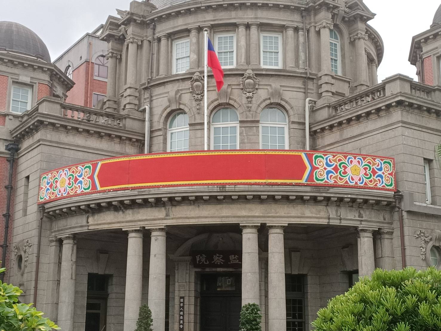 行憲紀念日25日這天，監察院雖在入口門樓裝飾了紅底看板，但看板上沒寫字、一片空白。圖/記者簡立欣攝